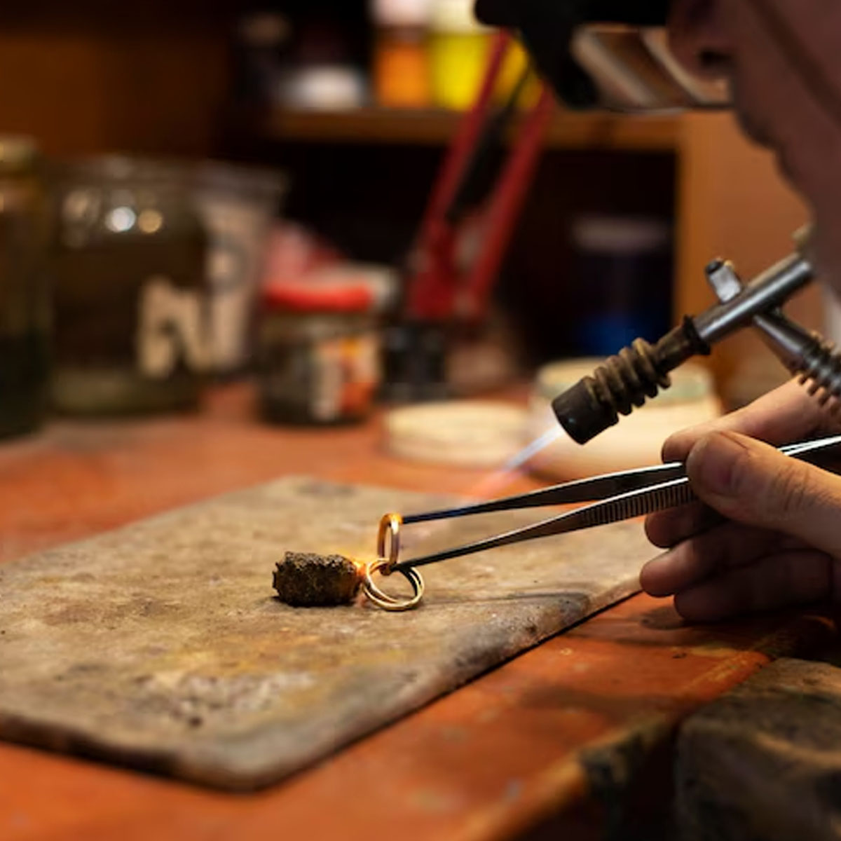 One-to-one studio instruction Master jeweller mentoring apprentice in intimate studio workshop setting